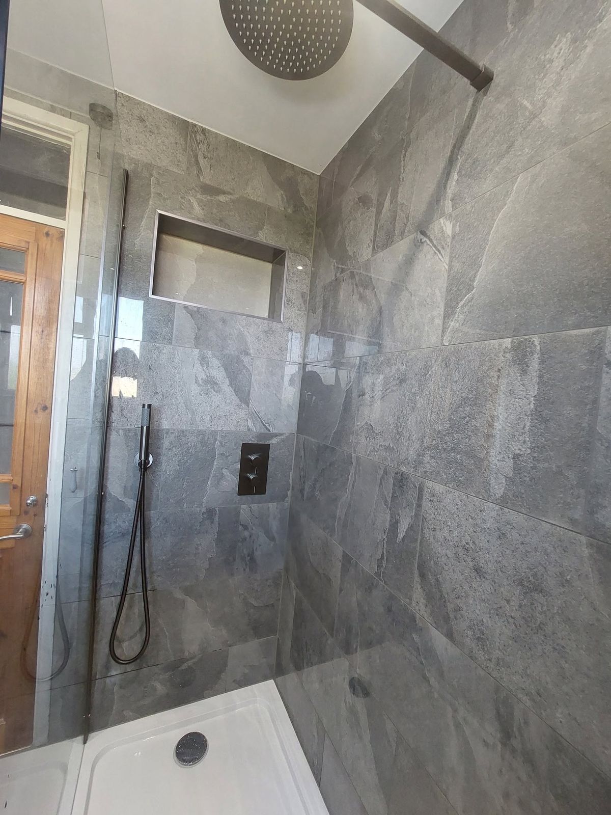 Grey-tiled walk-in with concealed thermostatic valve